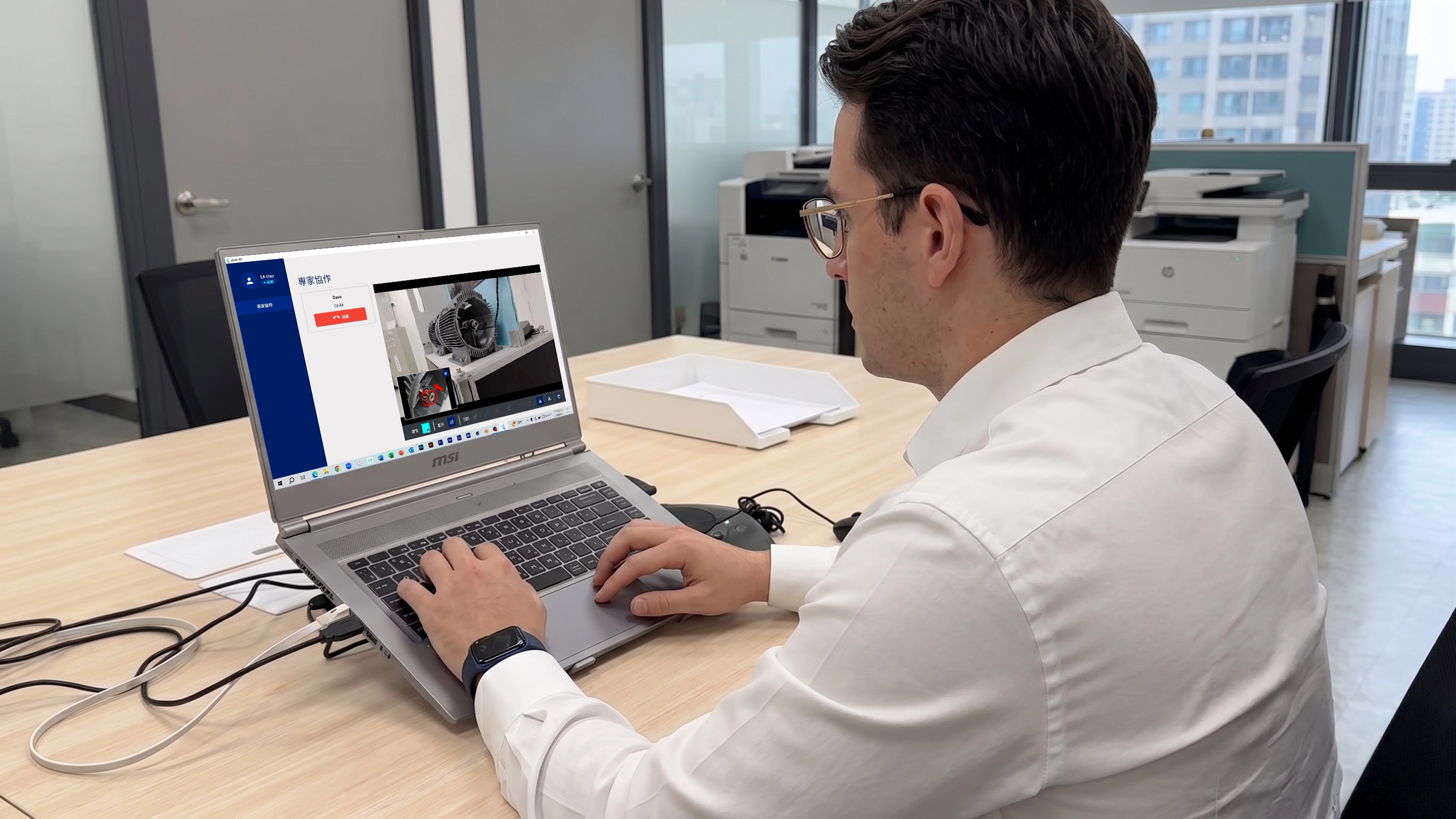 Remote expert checking motor video on laptop